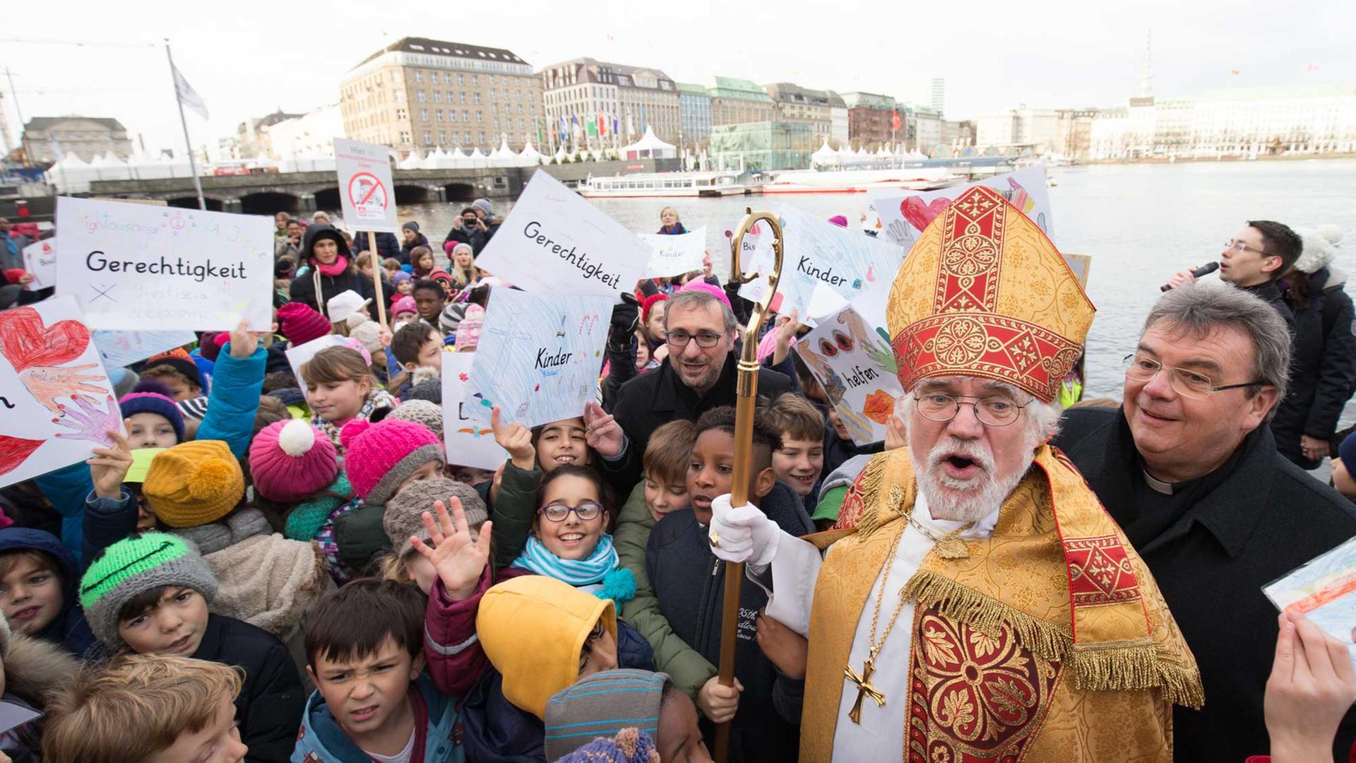 Rund 300 Hamburger Grundschüler begrüßen am 30.11.2015 am Alsteranleger in Hamburg den Heiligen Nikolaus, dargestellt von dem pensionierten Pfarrer und Flüchtlingsseelsorger Norbert Bezikofer. Rund 300 Hamburger Grundschüler begrüßen am 30.11.2015 am Alsteranleger in Hamburg den Heiligen Nikolaus, dargestellt von dem pensionierten Pfarrer und Flüchtlingsseelsorger Norbert Bezikofer.