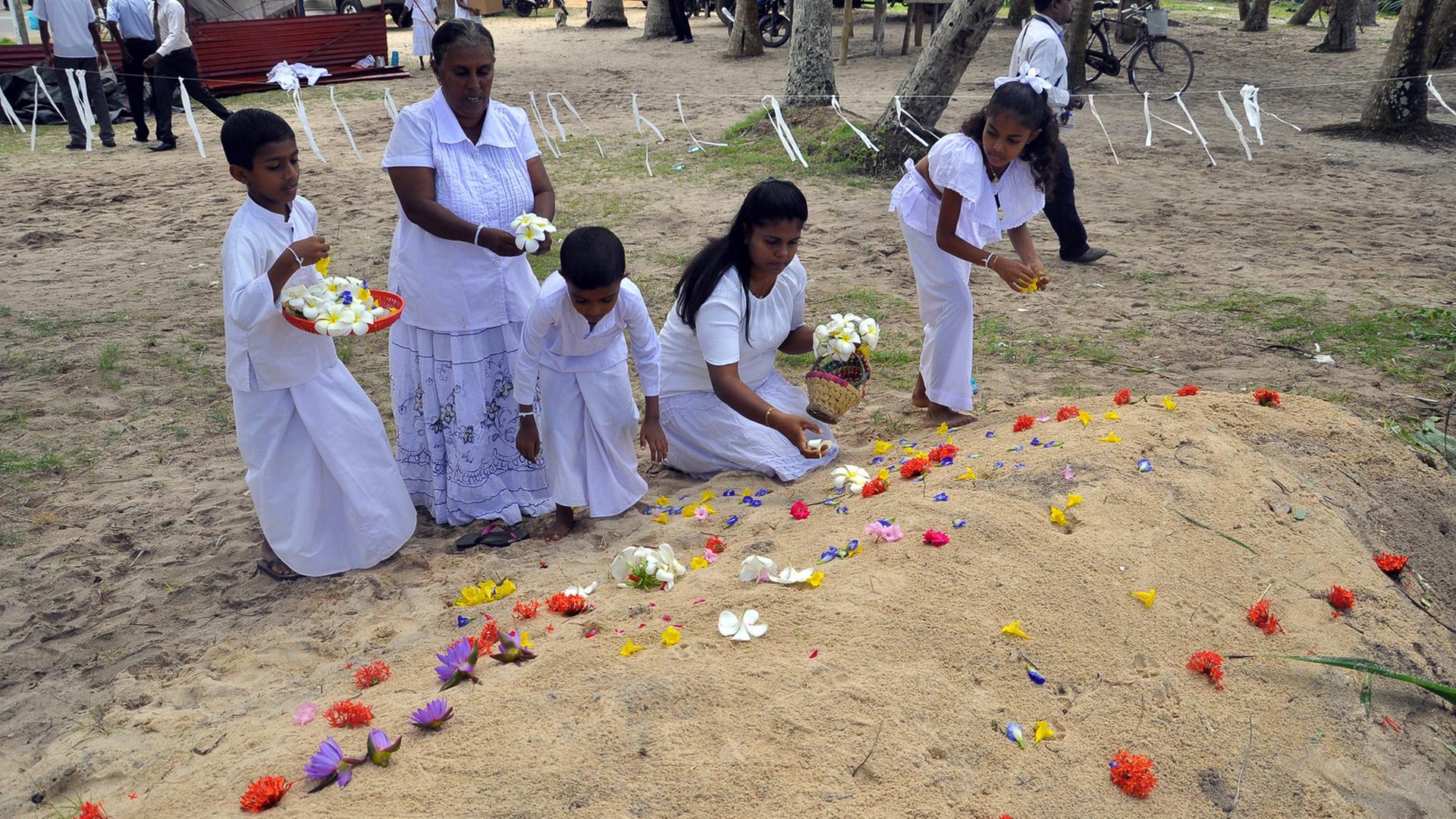 Trauernde legen Blumen an Gräbern von Tsunami-Opfern ab, die der Flutwelle vom Dezember 2004 zum Opfer fielen. Trauernde legen Blumen an Gräbern von Tsunami-Opfern ab, die der Flutwelle vom Dezember 2004 zum Opfer fielen.