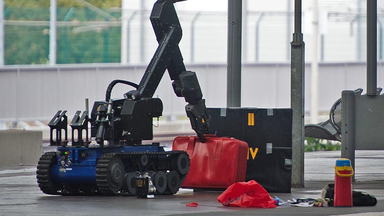 Ein ferngesteuerter Roboter zur Bombenentschärfung hebt am 08.10.2016 auf einem Gleis im Hauptbahnhof in Chemnitz (Sachsen) einen roten Koffer an. Ein ferngesteuerter Roboter zur Bombenentschärfung hebt am 08.10.2016 auf einem Gleis im Hauptbahnhof in Chemnitz (Sachsen) einen roten Koffer an.
