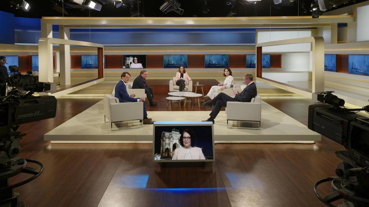 Im Studio der Anne Will-Talkshow sitzt die Moderatorin mit vier Gästen. Eine Expertin ist per Video zugeschaltet.