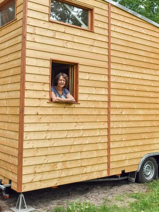 Sylvia Dreyer steht am Fenster ihres mobilen Hauses und schaut hinaus.