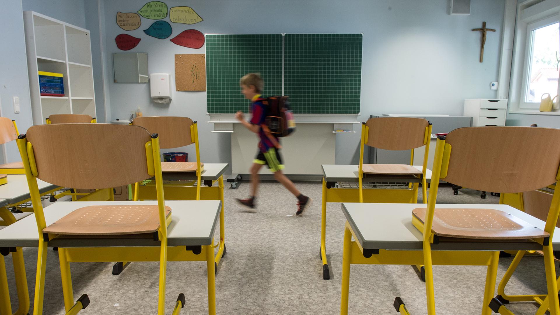Leeres Klassenzimmer mit hochgestellten Stühlen, aus dem ein Drittklässler läuft. Leeres Klassenzimmer mit hochgestellten Stühlen, aus dem ein Drittklässler läuft.
