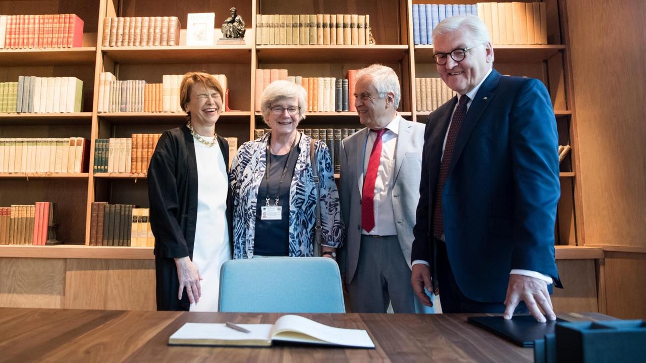 Bundespräsident Frank-Walter Steinmeier, Elke Büdenbender, Fridolin Mann und Christine Mann stehen im ehemaligen Arbeitszimmer von Thomas Mann, das in warmem Licht gehalten ist.Im Hintergrund befinden sich zahlreiche Bücher im Regal. Bundespräsident Frank-Walter Steinmeier, Elke Büdenbender, Fridolin Mann und Christine Mann stehen im ehemaligen Arbeitszimmer von Thomas Mann, das in warmem Licht gehalten ist.Im Hintergrund befinden sich zahlreiche Bücher im Regal.