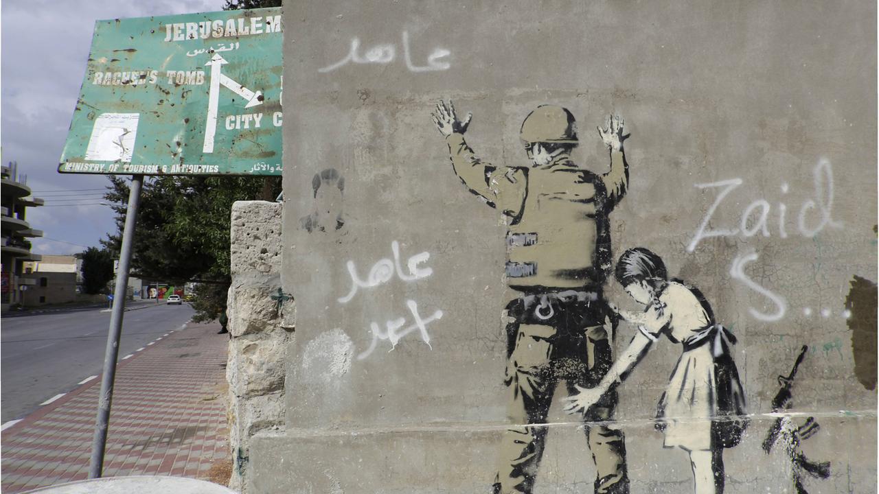 Sperrmauer mit Graffito von Banksy auf der palästinensischen Seite, zwischen Bethlehem, Westjordanland und Jerusalem. Sperrmauer mit Graffito von Banksy auf der palästinensischen Seite, zwischen Bethlehem, Westjordanland und Jerusalem.