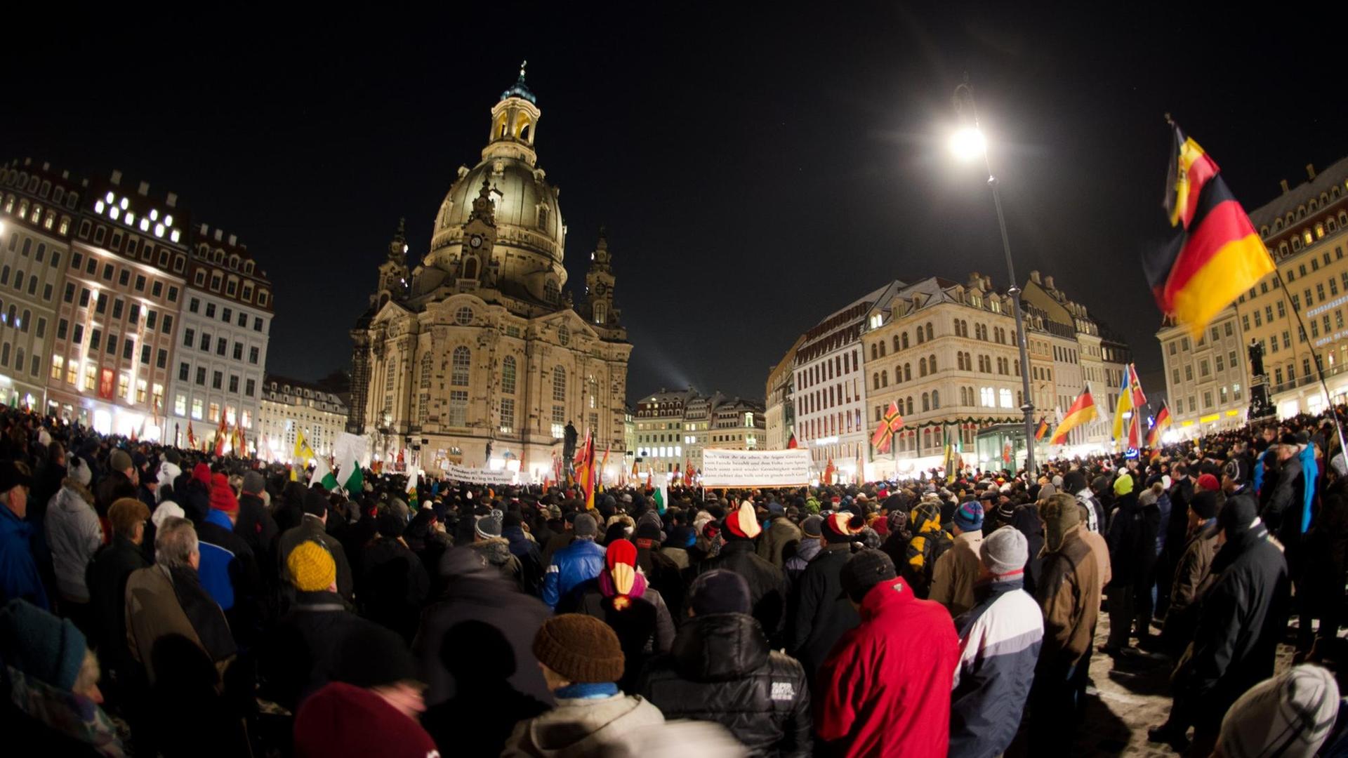 Menschenmenge mit Deutschlandfahnen vor der Dresdner Frauenkirche bei Dunkelheit. Menschenmenge mit Deutschlandfahnen vor der Dresdner Frauenkirche bei Dunkelheit.