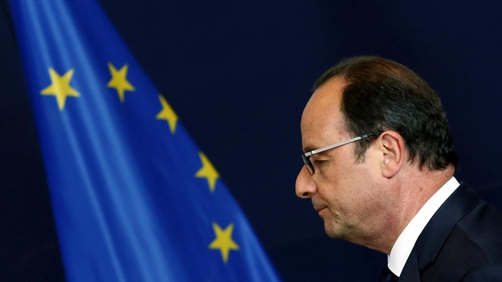 Der französische Präsident François Hollande neben einer EU-Flagge. Der französische Präsident François Hollande neben einer EU-Flagge.