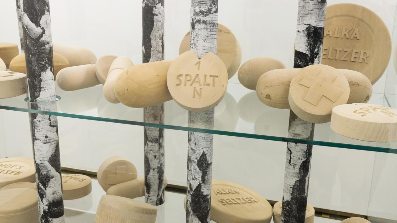 Das Werk " Jetzt geh ich in den Birkenwald, denn meine Pillen wirken bald " aus dem Jahr 1993 von Martin Kippenberger in der Ausstellung "And the FORESTs will echo with laughter..." der ERES-Stiftung München. Zu sehen sind in einer Glasvitrine, deren Regalbretter aus Glas - so scheint es - von dünnen Birkenstämmen getragen werden, Baumscheiben, die zu Pillen geschnitzt und geformt wurden. Das Werk " Jetzt geh ich in den Birkenwald, denn meine Pillen wirken bald " aus dem Jahr 1993 von Martin Kippenberger in der Ausstellung "And the FORESTs will echo with laughter..." der ERES-Stiftung München. Zu sehen sind in einer Glasvitrine, deren Regalbretter aus Glas - so scheint es - von dünnen Birkenstämmen getragen werden, Baumscheiben, die zu Pillen geschnitzt und geformt wurden.