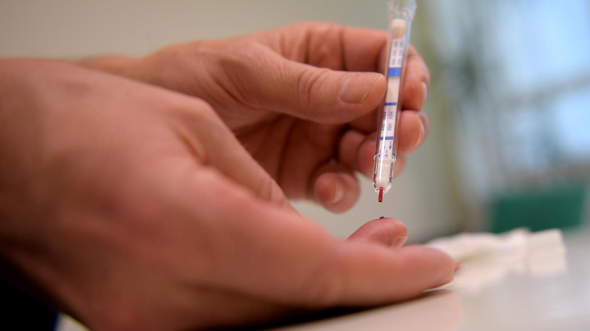 Ein junger Mann führt am 04.05.2017 in Berlin einen HIV-Heimtest durch Ein junger Mann führt am 04.05.2017 in Berlin einen HIV-Heimtest durch