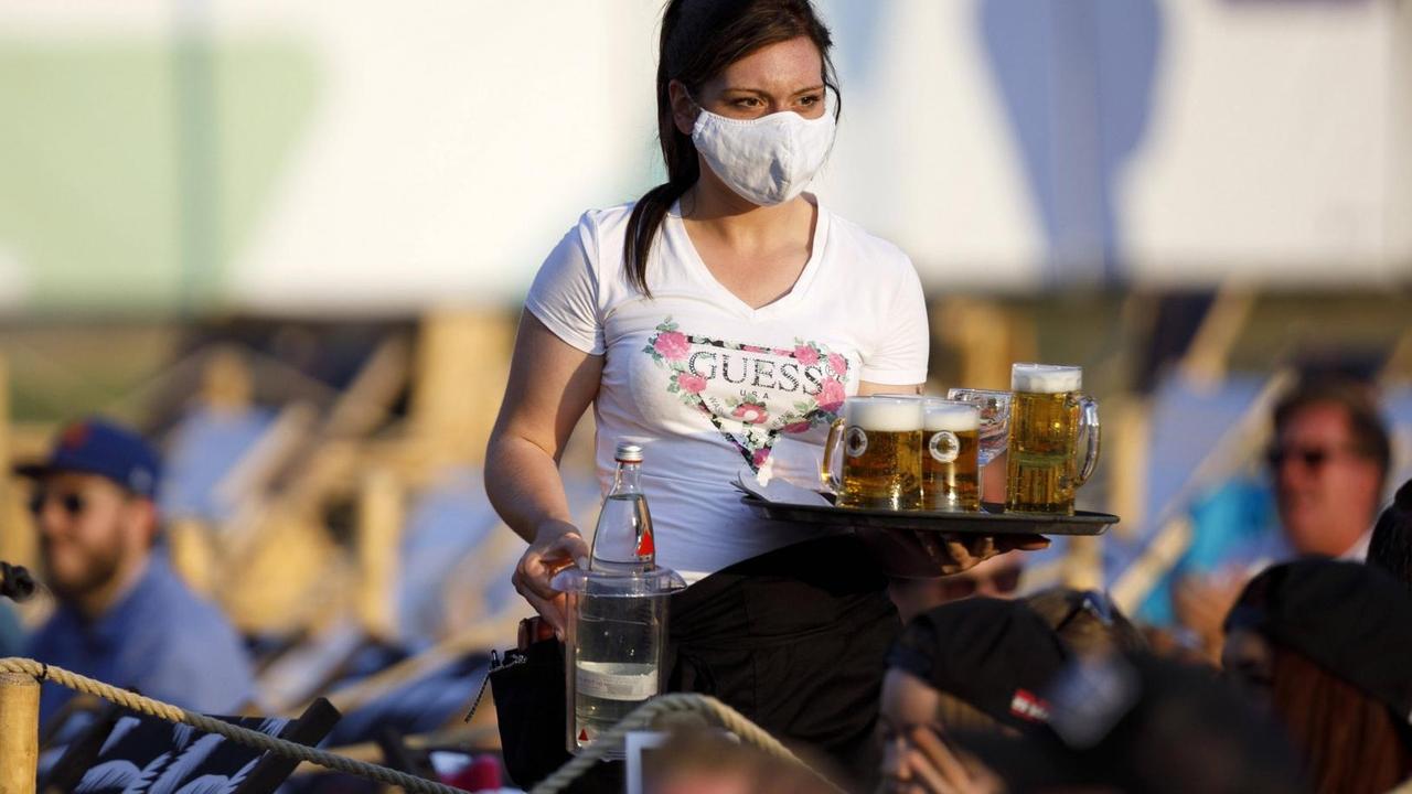 Eine Bedienung bringt Getränke beim Konzert von Mia Julia im Kulturgarten in der Bonner Rheinaue. Das Bonn Live Kulturgarten Open Air Festival 2020 ist Europas erstes Open Air Festival unter Corona-Auflagen wegen der Covid-19 Pandemie. Bedienungen tragen hier zum Schutz der Gäste Mundschutz. Bonn, 08.08.2020 *** A waitress brings drinks at Mia Julias concert in the Kulturgarten in the Rheinaue in Bonn The Bonn Live Kulturgarten Open Air Festival 2020 is Europes first open air festival under corona conditions due to the Covid 19 pandemic Waitresses wear face masks to protect the guests Bonn, 08 08 2020 Foto:xC.xHardtx/xFuturexImage Eine Bedienung bringt Getränke beim Konzert von Mia Julia im Kulturgarten in der Bonner Rheinaue. Das Bonn Live Kulturgarten Open Air Festival 2020 ist Europas erstes Open Air Festival unter Corona-Auflagen wegen der Covid-19 Pandemie. Bedienungen tragen hier zum Schutz der Gäste Mundschutz. Bonn, 08.08.2020 *** A waitress brings drinks at Mia Julias concert in the Kulturgarten in the Rheinaue in Bonn The Bonn Live Kulturgarten Open Air Festival 2020 is Europes first open air festival under corona conditions due to the Covid 19 pandemic Waitresses wear face masks to protect the guests Bonn, 08 08 2020 Foto:xC.xHardtx/xFuturexImage