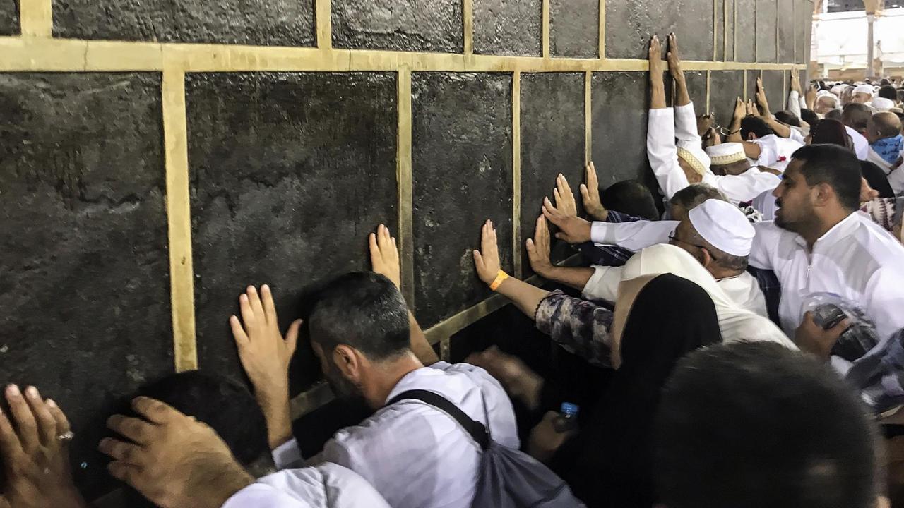 Muslimische Pilger berühren die heilige Kaaba in der Masjid al-Haram-Moschee in Mekka. Muslimische Pilger berühren die heilige Kaaba in der Masjid al-Haram-Moschee in Mekka.