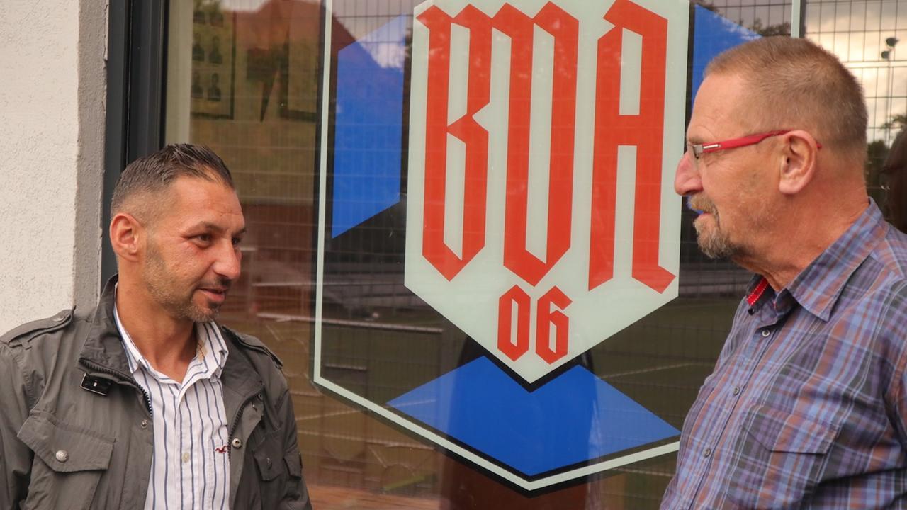 Hanenberg (rechts) im Gespräch vor dem Vereinslogo Hanenberg (rechts) im Gespräch vor dem Vereinslogo