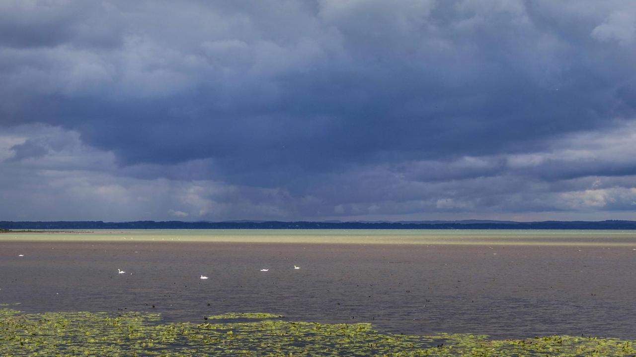 Dunkle Wolken über Wasserfläche Dunkle Wolken über Wasserfläche