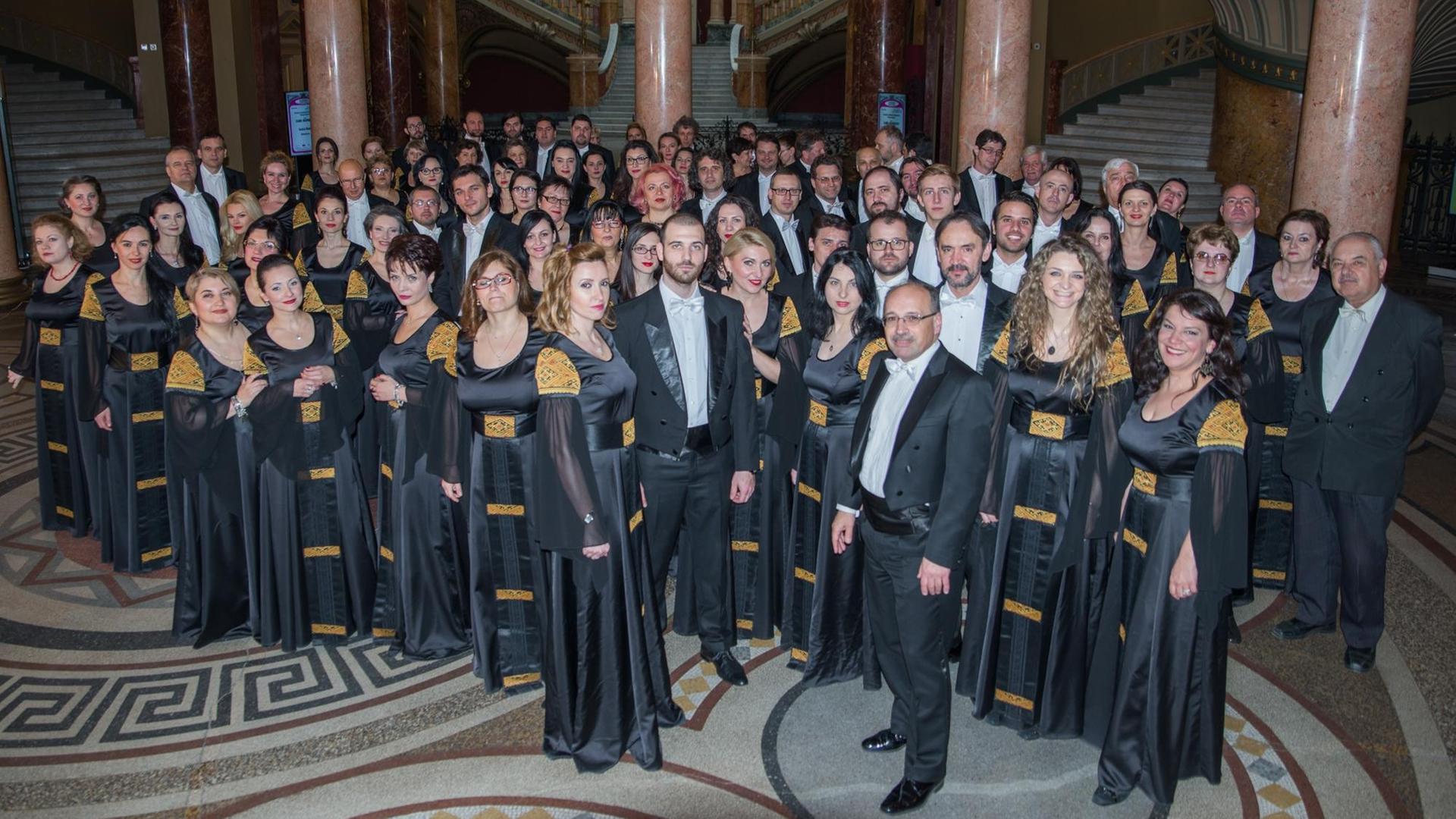 Der Philharmonische Chor „George Enescu“ steht in Auftrittsgarderobe versammelt um den Dirigenten Der Philharmonische Chor „George Enescu“ steht in Auftrittsgarderobe versammelt um den Dirigenten