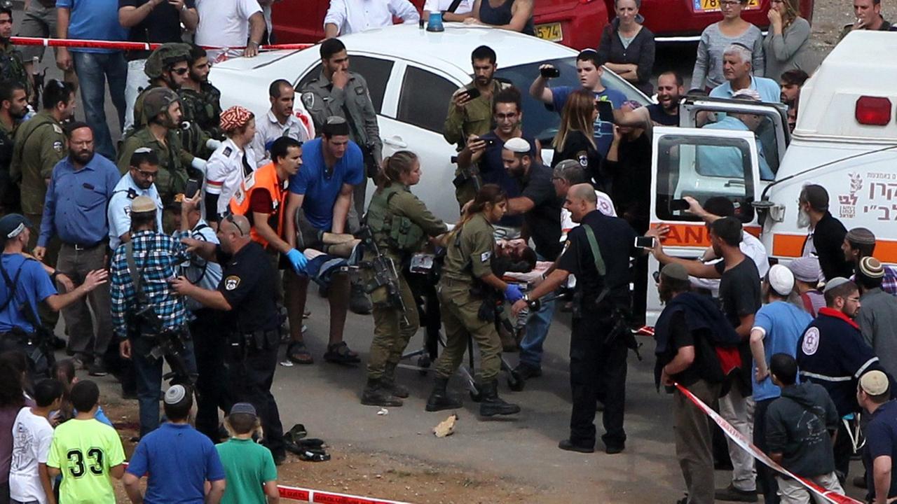 Israelische Rettungskräfte ladeb einen verletzten Palästinenser nahe Hebron in den Rettungswagen Israelische Rettungskräfte ladeb einen verletzten Palästinenser nahe Hebron in den Rettungswagen