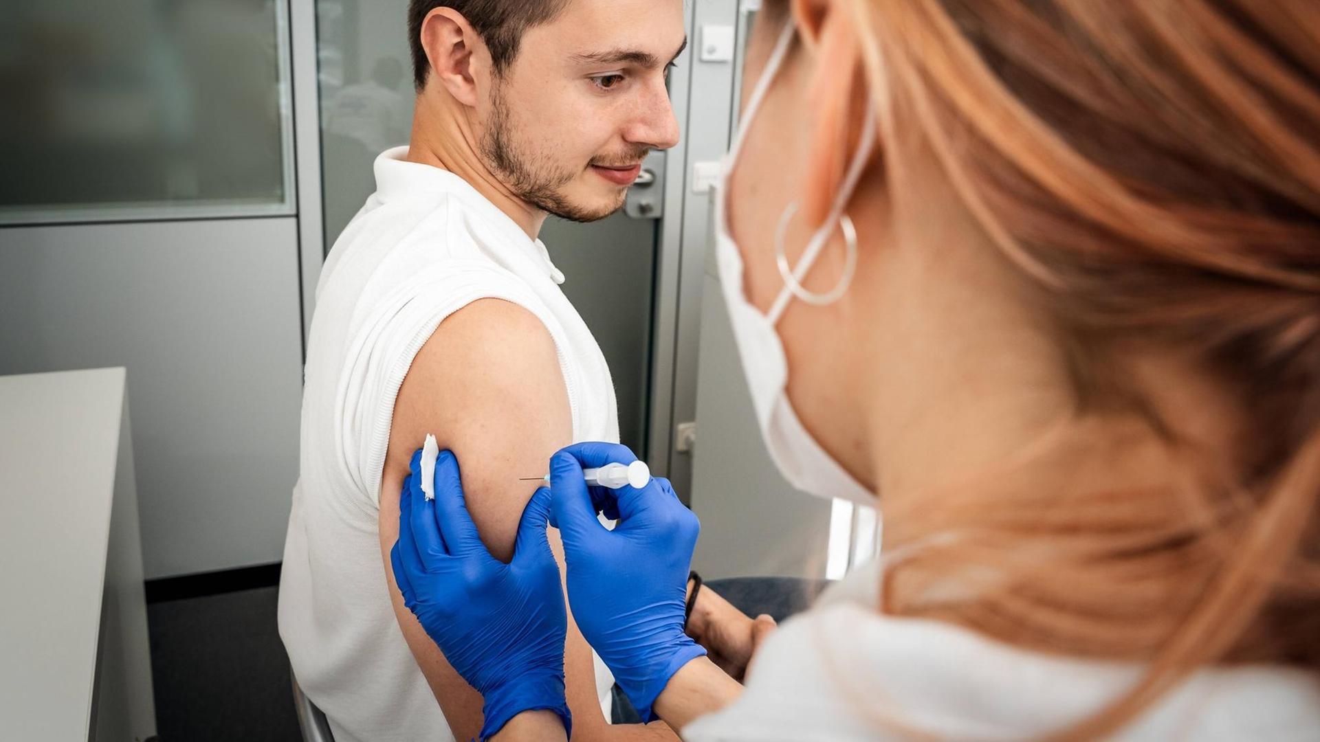 Eine Ärztin in Augsburg impft einen Impfling gegen Covid19.