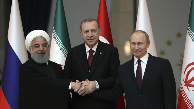 Türkei, Ankara: Hassan Ruhani (l-r), Präsident vom Iran, Recep Tayyip Erdogan, Präsident der Türkei, und Wladimir Putin, Präsident von Russland, geben sich bei einem Dreiergipfel zur Lage in Syrien in der türkischen Hauptstadt die Hand.