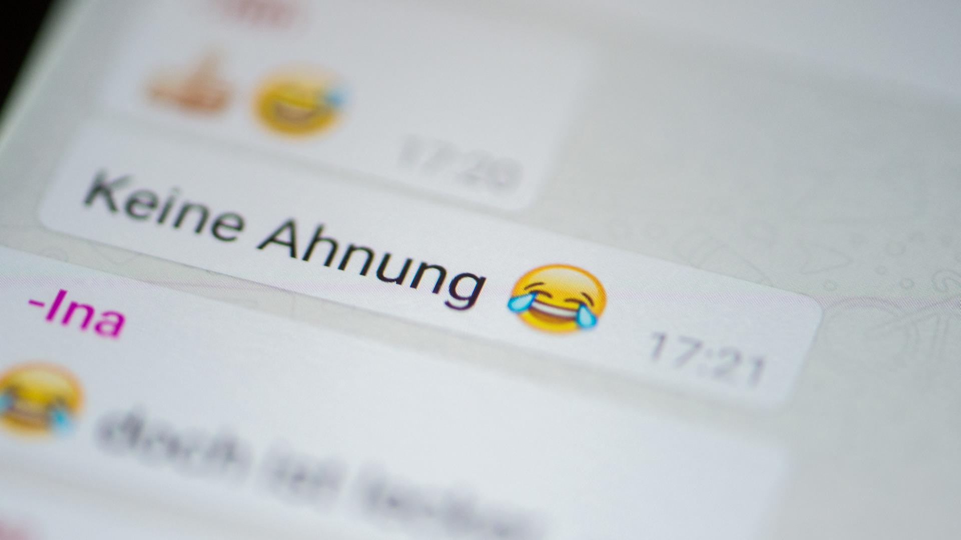 Ein Smartphone-Nutzer tippt auf ein Emoji, um es in eine WhatsApp-Nachricht einzufügen. Ein Smartphone-Nutzer tippt auf ein Emoji, um es in eine WhatsApp-Nachricht einzufügen.