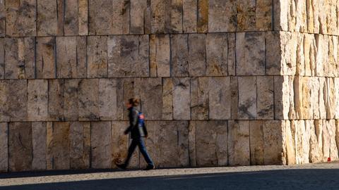 Eine Frau geht an der Münchner Ohel-Jakob-Synagoge in der Innenstadt vorbei.