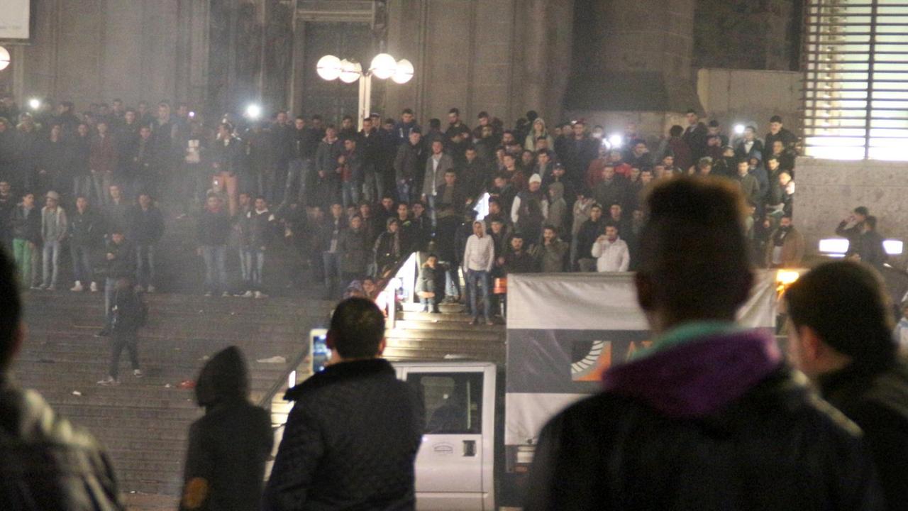 Man sieht viele Menschen am Kölner Hauptbahnhof in der Silvesternacht, im Hintergrund die Freitreppe zum Dom. Man sieht viele Menschen am Kölner Hauptbahnhof in der Silvesternacht, im Hintergrund die Freitreppe zum Dom.