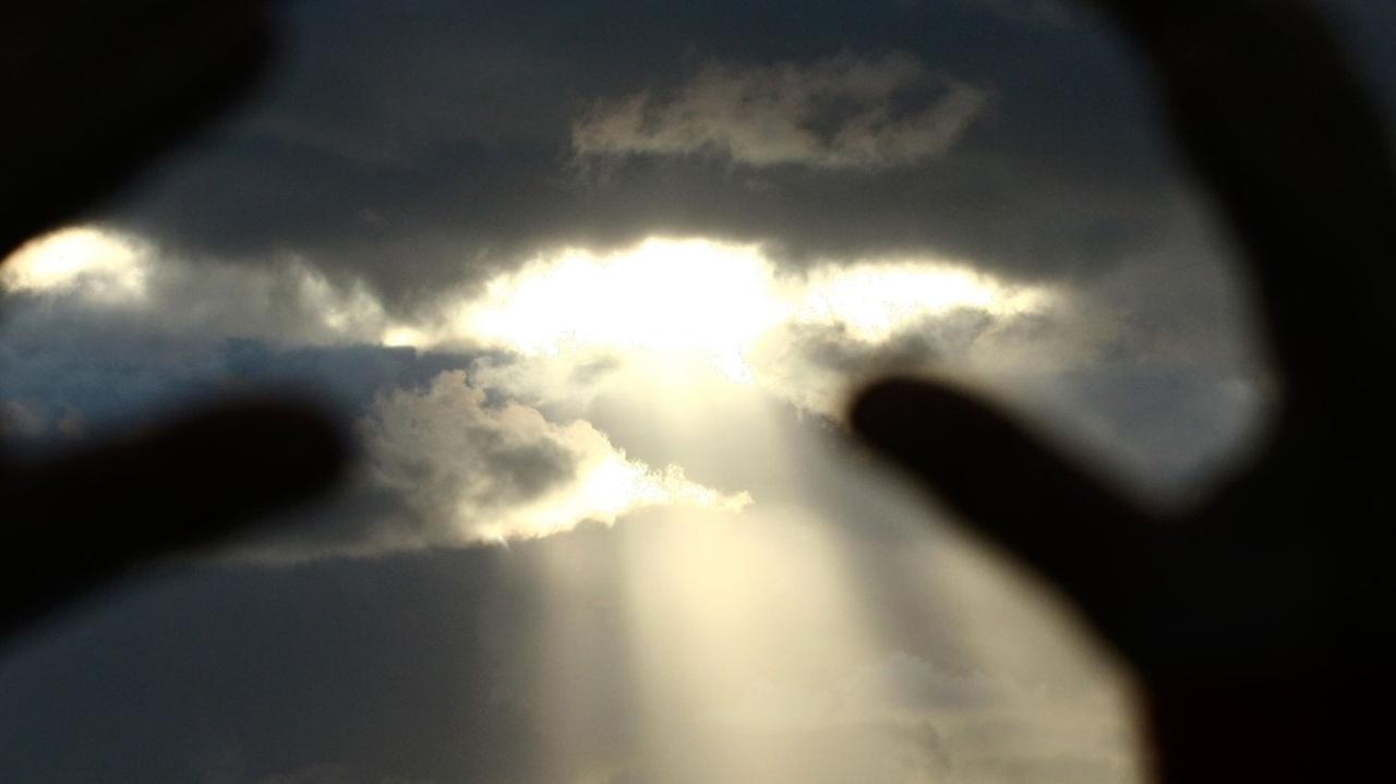 Hände versuchen, die letzten Sonnenstrahlen des Tages einzufangen. Hände versuchen, die letzten Sonnenstrahlen des Tages einzufangen.