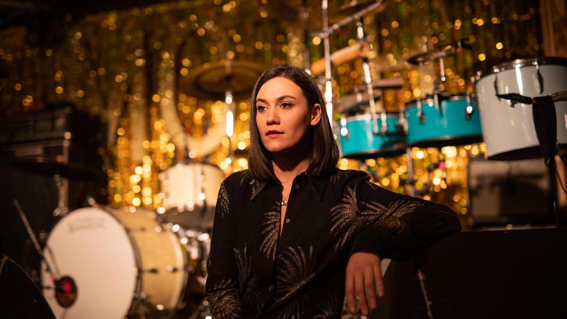 Die Musikerin Nadine Shah posiert vor einer Konzertbühne