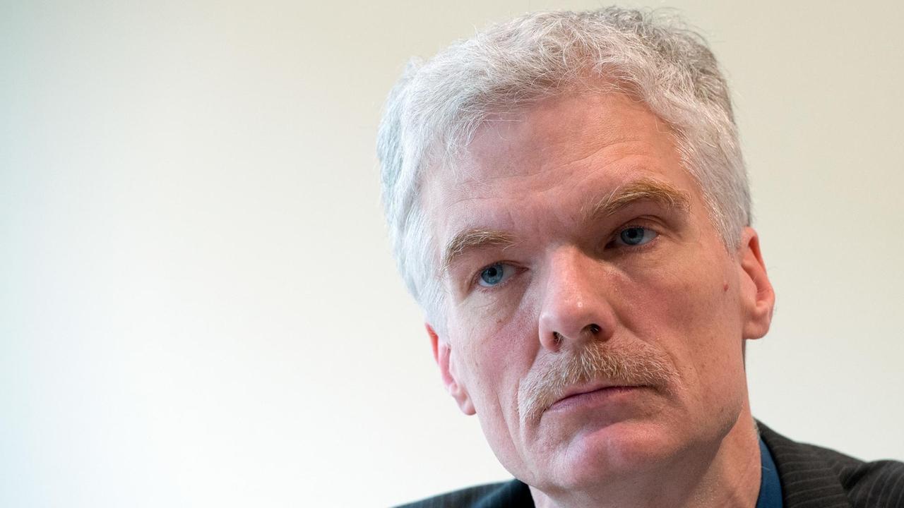 Nahaufnahme vom Kopf des grauhaarigen Schleicher mit Schnurrbart. Er hört der (nicht sichtbaren) Fragenstellerin aufmerksam zu. Nahaufnahme vom Kopf des grauhaarigen Schleicher mit Schnurrbart. Er hört der (nicht sichtbaren) Fragenstellerin aufmerksam zu.