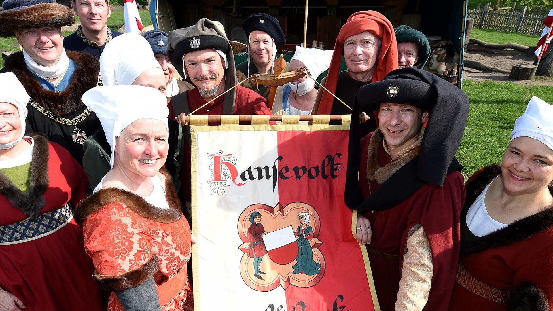 Darsteller des "Hansevolk zu Lübeck" zeigen am 27.04.2014 in Lübeck (Schleswig-Holstein) ihre Fahne.