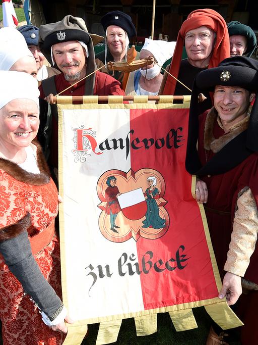 Darsteller des "Hansevolk zu Lübeck" zeigen am 27.04.2014 in Lübeck (Schleswig-Holstein) ihre Fahne.