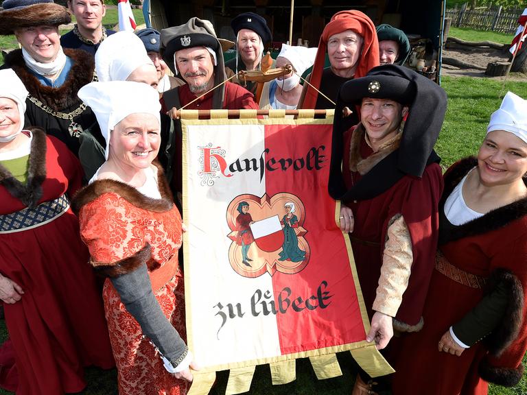 Darsteller des "Hansevolk zu Lübeck" zeigen am 27.04.2014 in Lübeck (Schleswig-Holstein) ihre Fahne.
