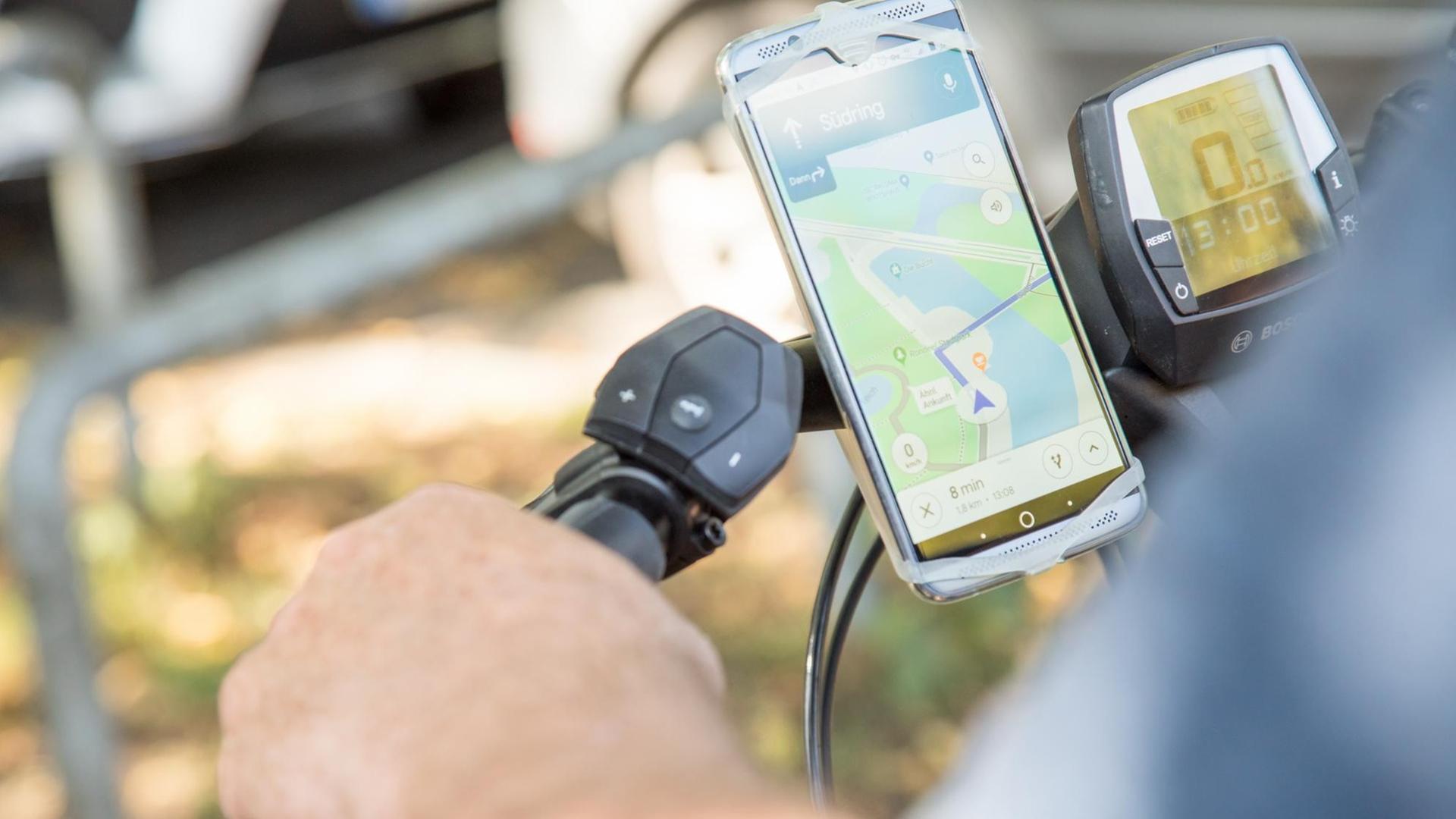 Ein älterer Mann befestigt ein Smartphone zur Navigation an seinem Fahrrad. Ein älterer Mann befestigt ein Smartphone zur Navigation an seinem Fahrrad.