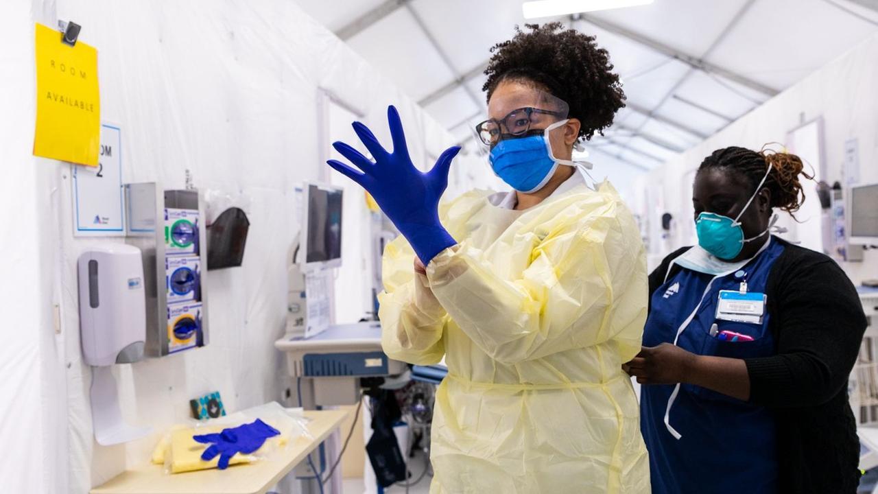 Auf dem Foto "Teamwork" der Fotografin Claudia Paul sind zwei Mitarbeiterinnen der Mount Sinai Hospitals zusehen, die sich Schutzkleidung wegen der Coronapandemie anziehen. 