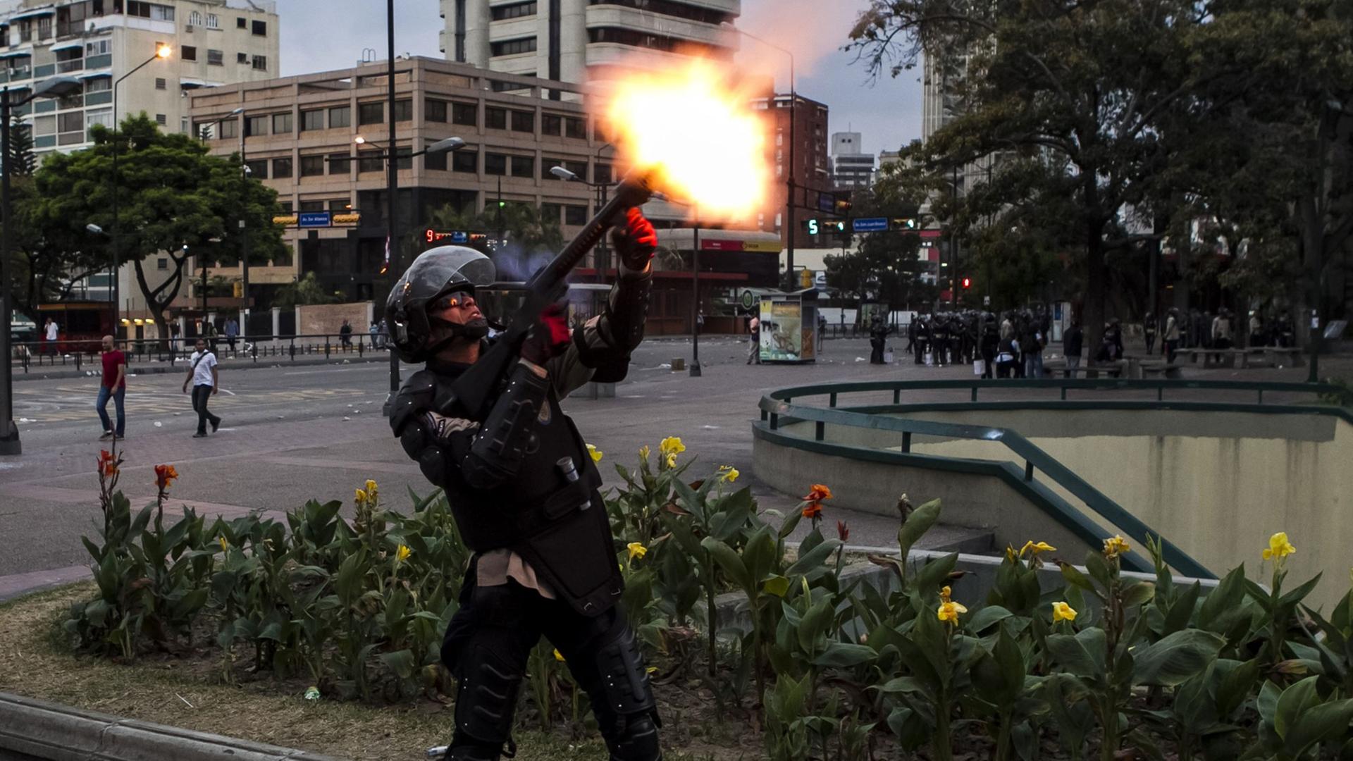 Ein Mitglied der venezolanischen Nationalpolizei schießt einen Tränengaskanister mit einem Gewehr ab, um regierungskritische Demonstranten zu vertreiben, aufgenommen 2014. Ein Mitglied der venezolanischen Nationalpolizei schießt einen Tränengaskanister mit einem Gewehr ab, um regierungskritische Demonstranten zu vertreiben, aufgenommen 2014.