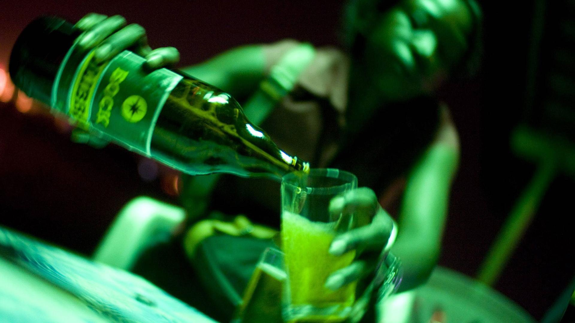 Eine Kellnerin schenkt in einer Bar in Abidjan/Elfenbeinküste ein Bier ein. Eine Kellnerin schenkt in einer Bar in Abidjan/Elfenbeinküste ein Bier ein.