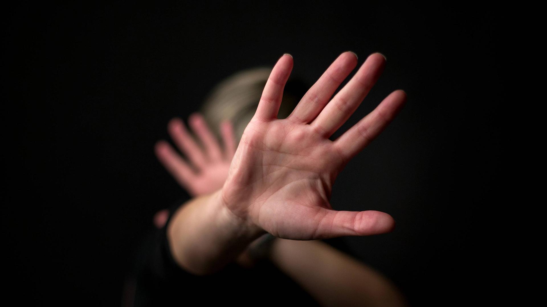Eine Frau hält sich die Hände vor das Gesicht. Eine Frau hält sich die Hände vor das Gesicht.