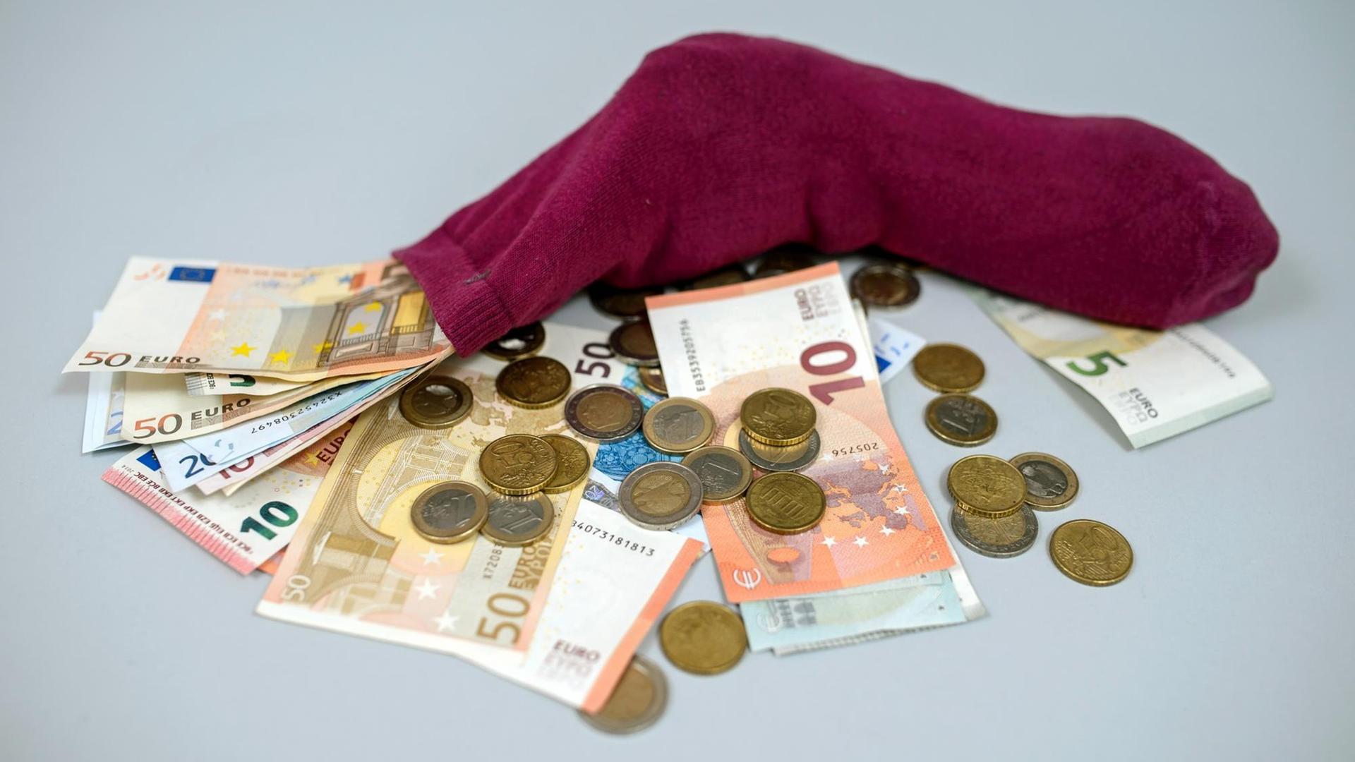 Geldscheine und Münzen stecken in einem Strumpf. Geldscheine und Münzen stecken in einem Strumpf.