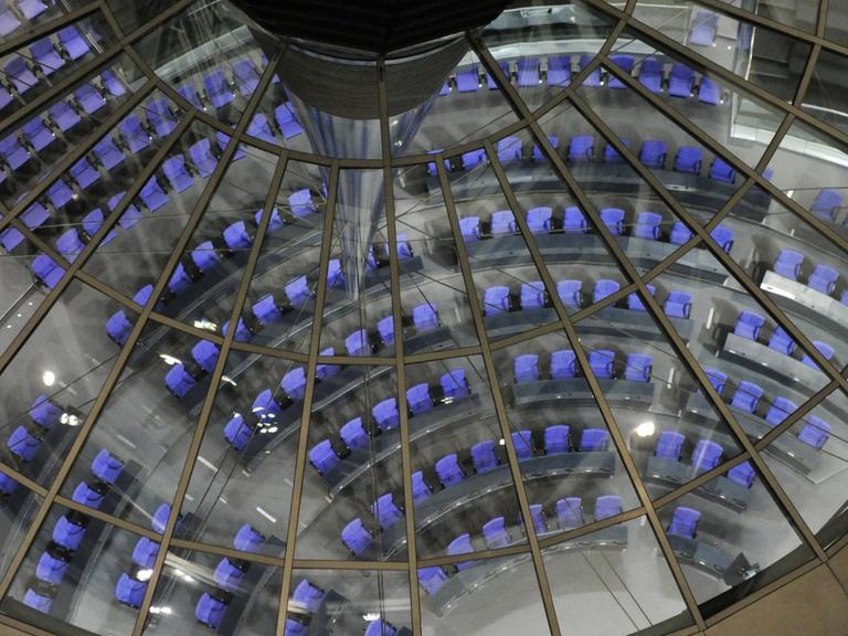 Die Sitze des Bundestags in Berlin im Reichstagsgebäude durch die Glaskuppel von oben gesehen.