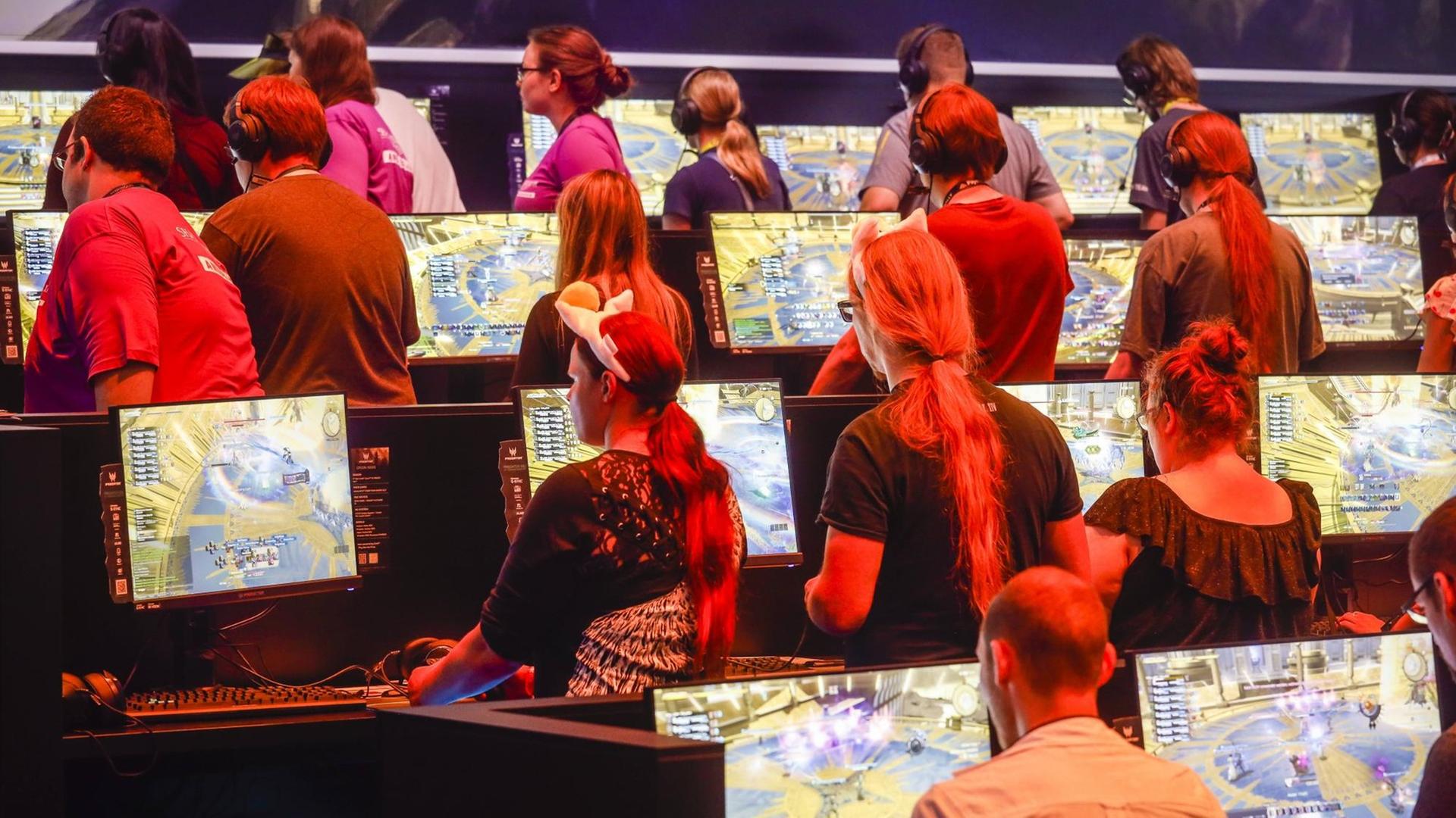 Messebesucher spielen auf der Messe Gamescom das Computerspiel Final Fantasy XIV