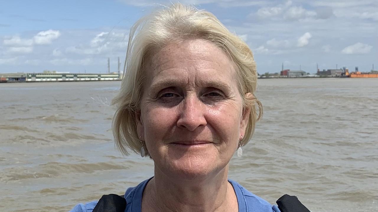 Eine Frau mit halblangen blonden Haaren steht am Wasser. Eine Frau mit halblangen blonden Haaren steht am Wasser.