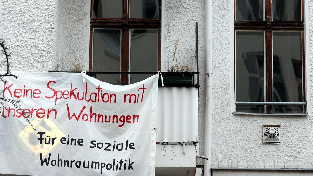 Ein Transparent gegen Wohnungsspekulationen hängt an einer Fassade eines Mietshauses im Berliner Bezirk Friedrichshain. Ein Transparent gegen Wohnungsspekulationen hängt an einer Fassade eines Mietshauses im Berliner Bezirk Friedrichshain.