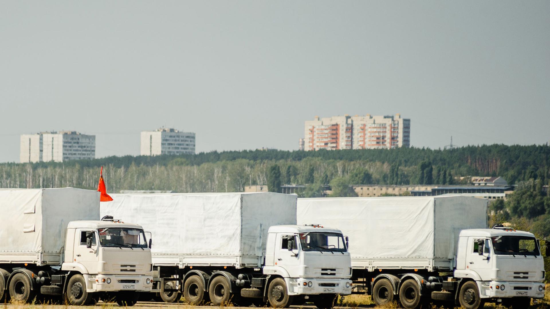 Drei Lastwagen des russischen Konvois für die Ost-Ukraine warten am 13.08.14 in der Nähe der Stadt Woronesch, etwa 400 Kilometer von Moskau entfernt.