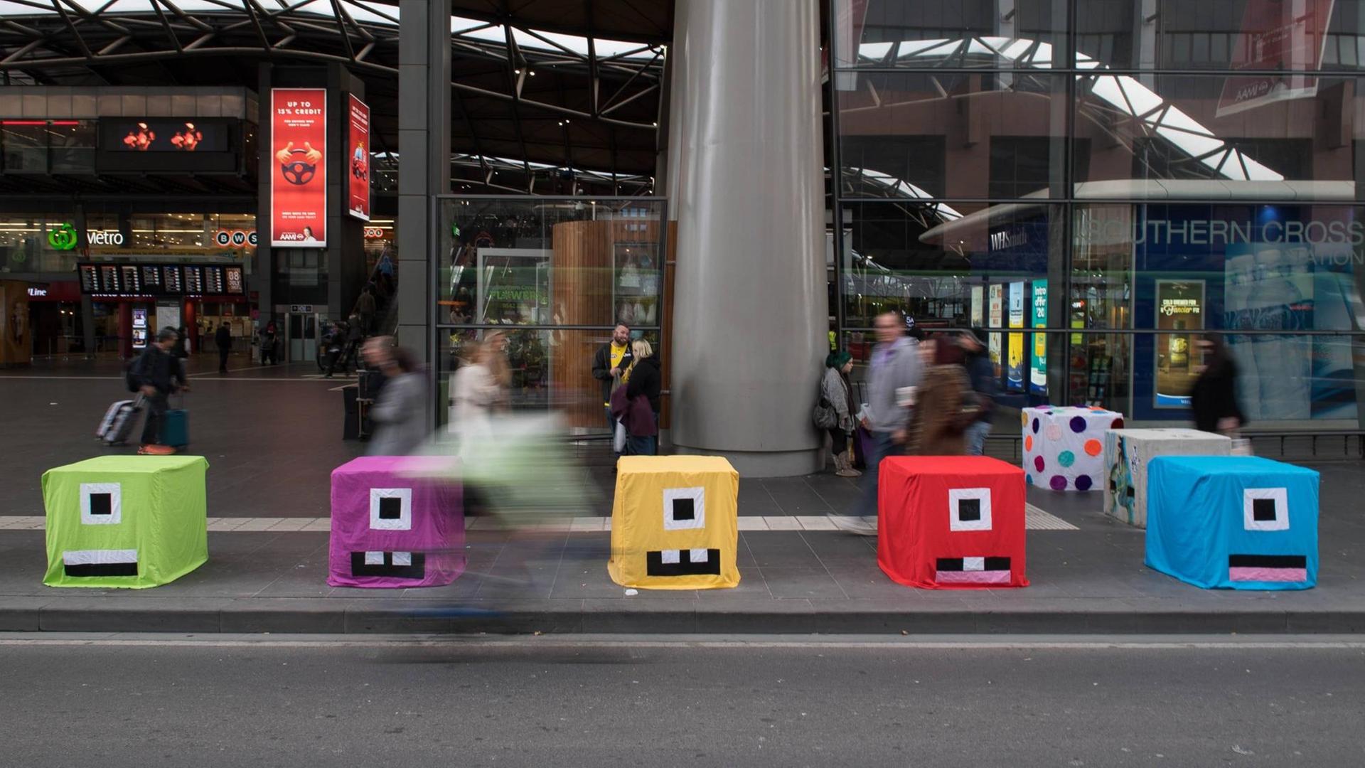 An der Southern Cross Station passieren Fußgänger am 8. Juli 2017 quadratische und farbig gestaltete Betonblöcke, die gegen die Terrorgefahr neu installiert worden sind.