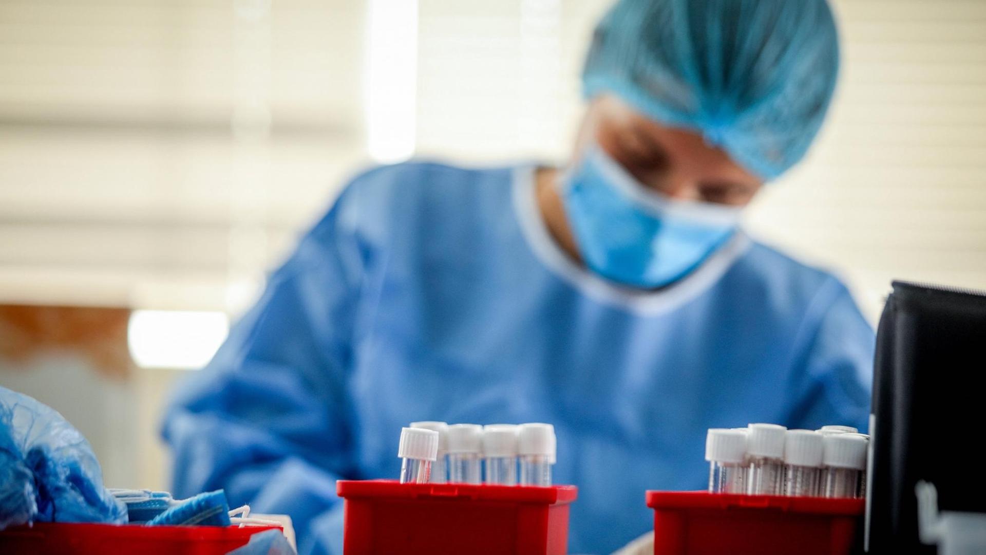 Krankenpflegerin und Röhrchen für PCR-Tests auf COVID-19 Krankenpflegerin und Röhrchen für PCR-Tests auf COVID-19