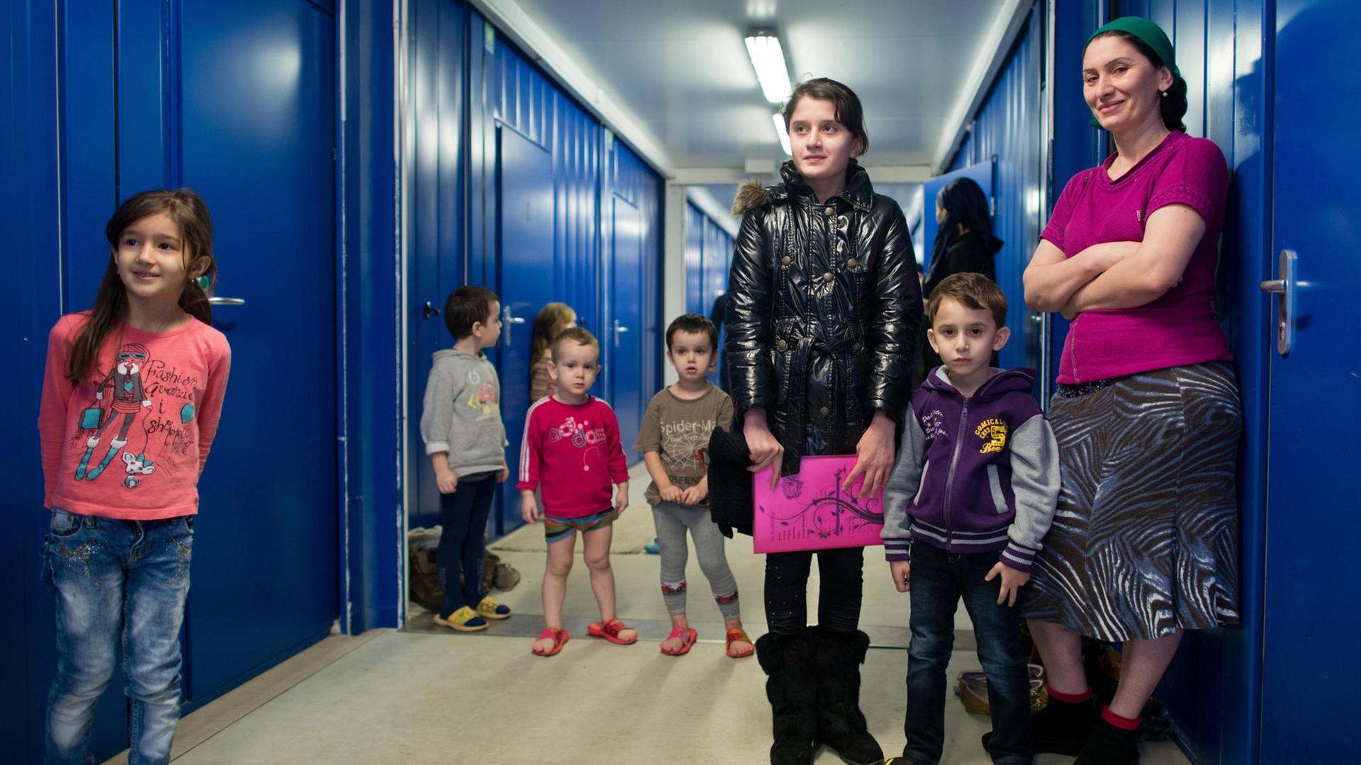 Eine Frau und viele Kinder aus Tschetschenien stehen am 26.02.2013 in einem Wohncontainer auf dem Gelände der Zentralen Ausländerbehörde des Landes Brandenburg in Eisenhüttenstadt (Brandenburg). Eine Frau und viele Kinder aus Tschetschenien stehen am 26.02.2013 in einem Wohncontainer auf dem Gelände der Zentralen Ausländerbehörde des Landes Brandenburg in Eisenhüttenstadt (Brandenburg).