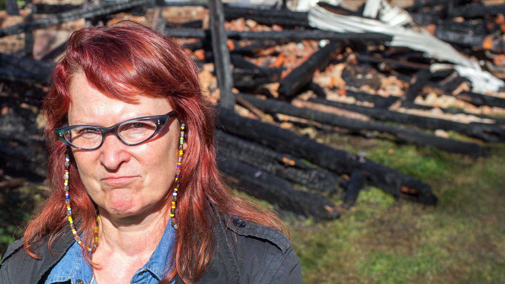 Birgit Lohmeyer steht am 13. August 2015 vor den Resten ihrer verbrannten Scheune in Jamel. Birgit Lohmeyer steht am 13. August 2015 vor den Resten ihrer verbrannten Scheune in Jamel.