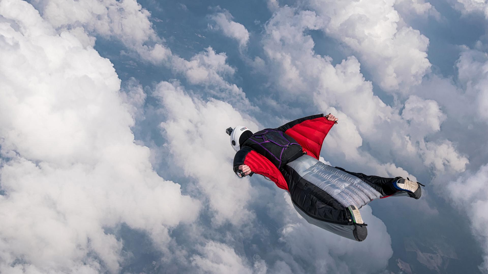 Ein Fallschirmspringer in freiem Fall. wing.suit - Dramatische Dreiecksgeschichte Ein Fallschirmspringer in freiem Fall. wing.suit - Dramatische Dreiecksgeschichte