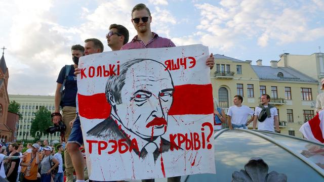 16.08.2020, Belarus, Minsk: "Wie viel Blut braucht es noch?" steht auf dem Plakat mit dem Gesicht von Machthaber Lukaschenko, das ein junger Mann auf dem Unabhängigkeitsplatz hält. Z