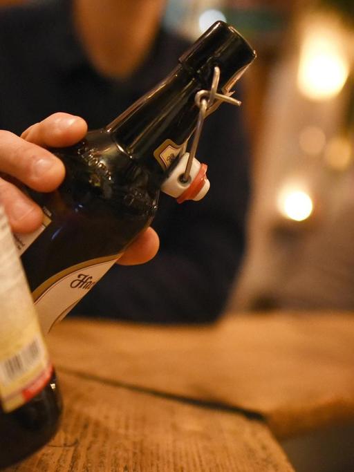 Zwei Personen stoßen am 30.11.2016 in Garmisch-Partenkirchen (Bayern) in einer Kneipe mit Bier in der Flasche an.