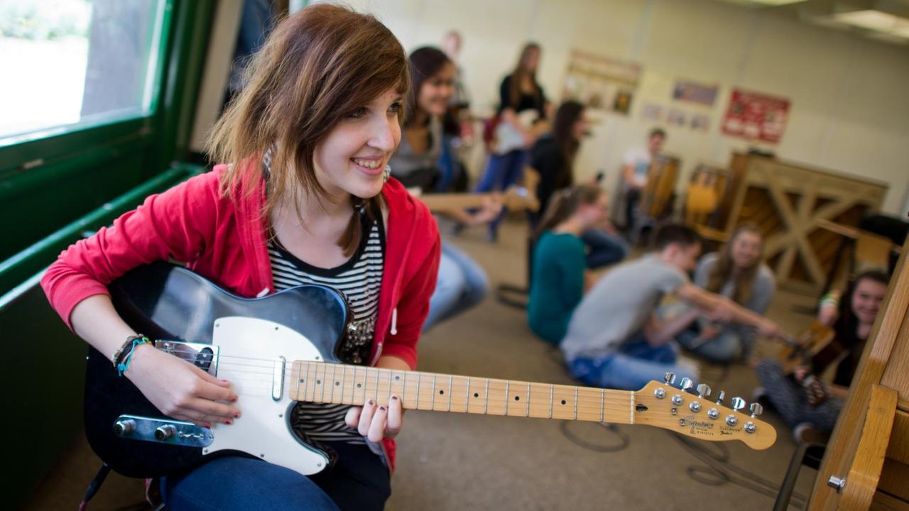 Eine Schülerin probt mit ihrer Schulklasse in einem Musikraum der Wilhelm Bracke Gesamtschule in Braunschweig (Niedersachsen). Eine Schülerin probt mit ihrer Schulklasse in einem Musikraum der Wilhelm Bracke Gesamtschule in Braunschweig (Niedersachsen).