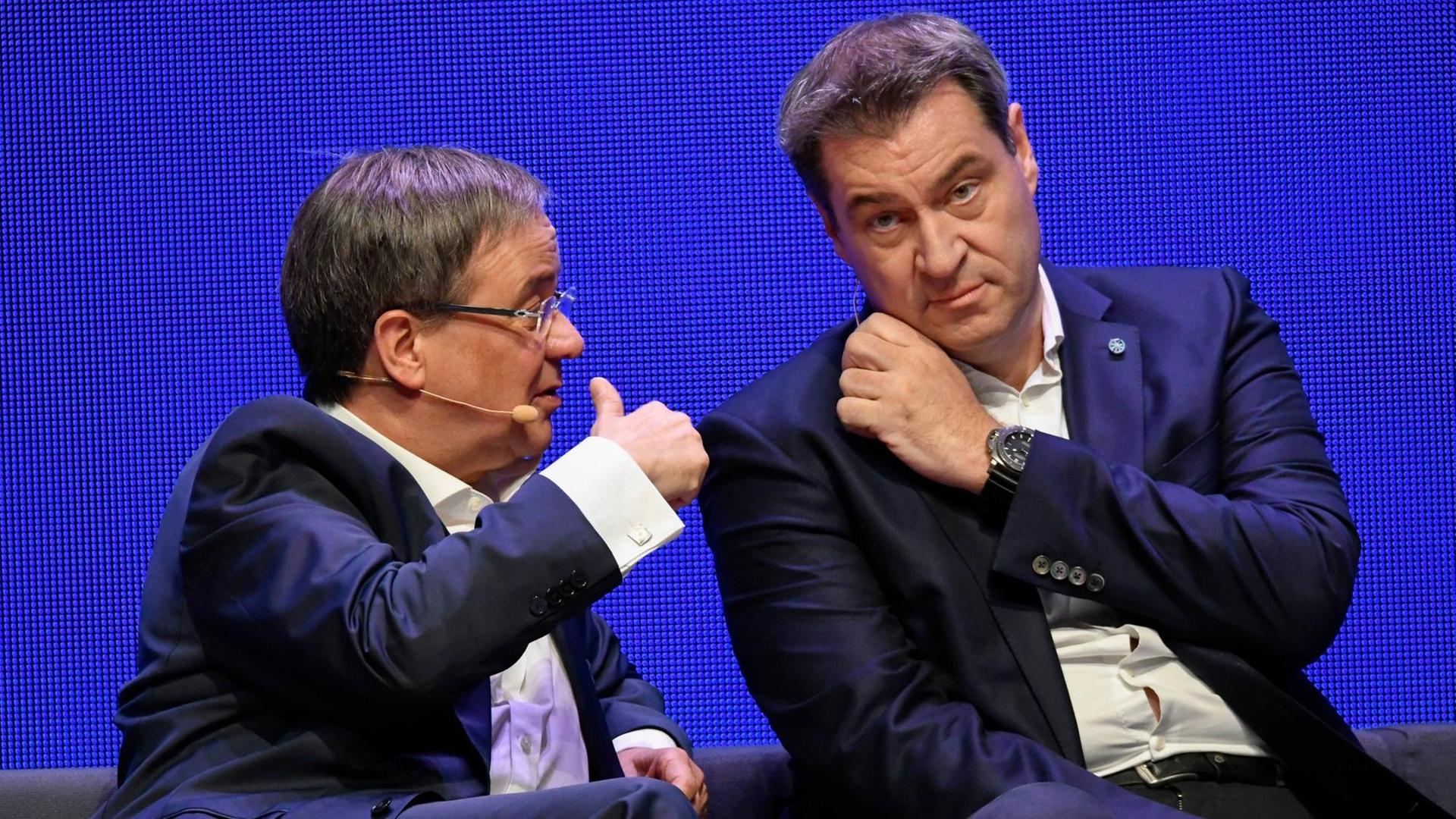 Nordrhein-Westfalens Ministerpräsident Armin Laschet (links) sitzt neben seinem bayerischen Amtskollegen Markus Söder und unterhält sich bei einer Veranstaltung 2019 in Münster mit ihm Nordrhein-Westfalens Ministerpräsident Armin Laschet (links) sitzt neben seinem bayerischen Amtskollegen Markus Söder und unterhält sich bei einer Veranstaltung 2019 in Münster mit ihm