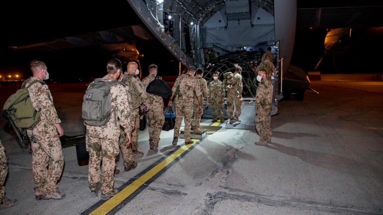 Bundes-Wehr-Soldaten an einem Militär-Flugzeug Bundes-Wehr-Soldaten an einem Militär-Flugzeug